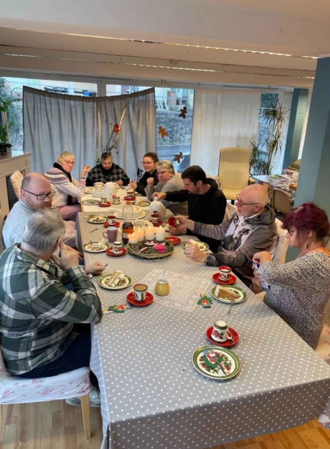 Soziale Teilhabe Kilian und Partner – sozialpädagogische Hilfe – eine Gruppe von Menschen genießt einen ruhigen Moment einer Weihnachtsfeier